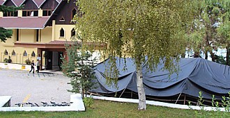 Otel kapatıp bahçesine çadır kurdu