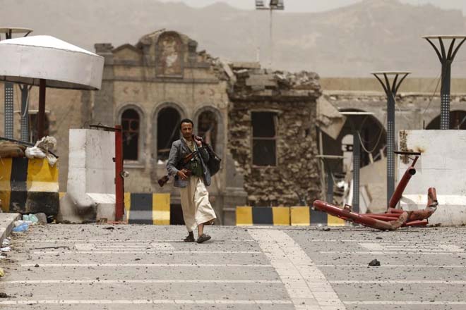 Yemen'in başkenti Sana'da Suudi bombalarıyla enkaza dönen Savunma Bakanlığı önünde bir Hutsi militan.